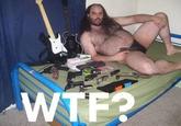 Fat hairy man in a speedo with guns and Guitar Hero controllers